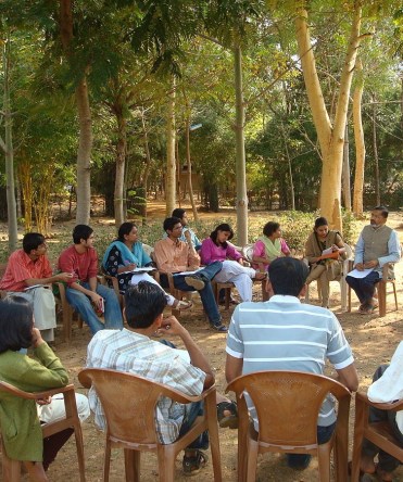 Group discussion in the camps of Nirman (cropped), by Abhijeet Safai, Public Domain via Wikimedia Commons