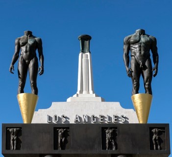 The Olympic Gateway arch and male and female statues at the entrance to the Los Angeles Memorial Coliseum, Los Angeles, California by Robert Graham, public domain via Library of Congress