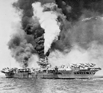 Kamikaze attack left HMS Formidable burning, 1945, by Royal Navy photographer aboard HMS Victorious (cropped), public domain via Wikimedia Commons